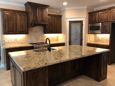 a kitchen with marble counter tops and wooden cabinets