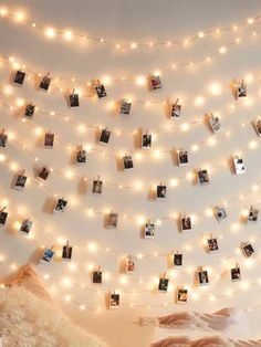 a bedroom with lights strung from the ceiling and pictures hanging on the wall above it