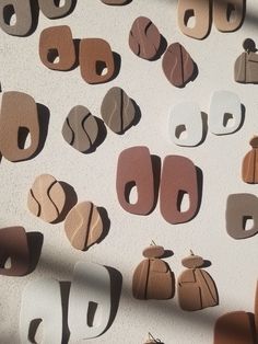 many different shapes and sizes of wooden earring hooks on a white surface with shadows