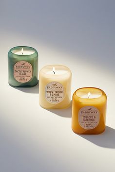 three candles sitting next to each other on a white surface