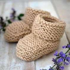 a pair of crocheted baby booties sitting on top of a wooden floor