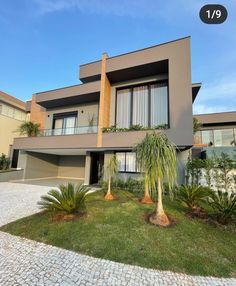 a house that is in the middle of some grass and plants on the front lawn