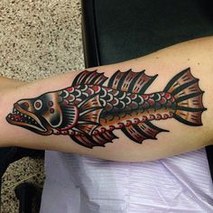 a colorful fish tattoo on the arm