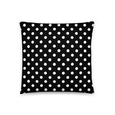 a black pillow with white polka dots on the front and back, which has a square shape