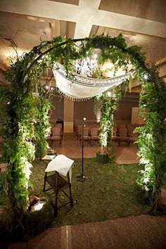 an outdoor wedding setup with greenery and lights