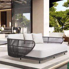 an outdoor living area with white furniture and trees