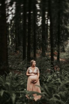 a woman standing in the middle of a forest