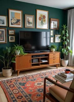 a living room with green walls and pictures on the wall, plants in vases