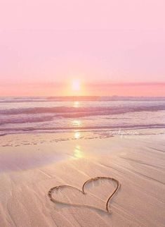 a heart drawn in the sand on a beach