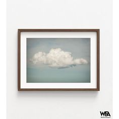 a white cloud is floating in the sky above some brown framed pictures on a wall