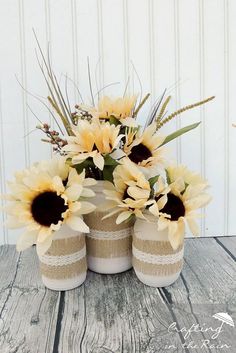 two vases with sunflowers are sitting on a table