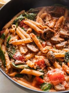 a pan filled with pasta and vegetables on top of a table