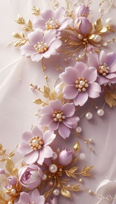 some pink flowers and gold leaves on a white background with pearls in the middle,