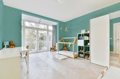 a bedroom with blue walls and white furniture