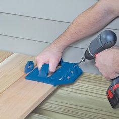 a man using a drill to attach a piece of wood