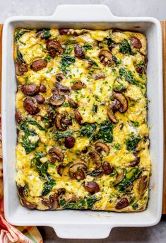 a casserole dish with mushrooms, spinach and cheese