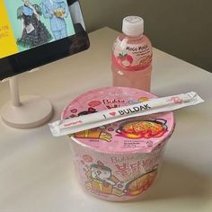 an ice cream cup with some kind of candy in it next to a computer monitor