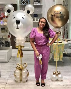 a woman standing in front of some balloons