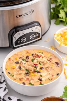 a bowl of chicken chili next to an instant pot