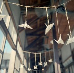 some paper cranes are hanging from a string