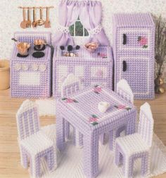 a dollhouse kitchen with purple furniture and accessories