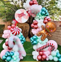 an outdoor birthday party with balloons and decorations in the shape of numbers, candy canes, gingerbread man