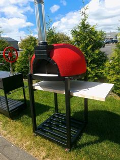 an outdoor pizza oven sitting on top of a grass covered field next to a park bench