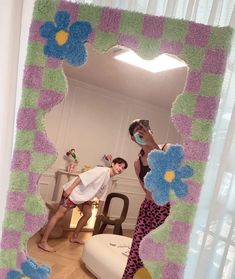 two people standing in front of a mirror with flowers on it