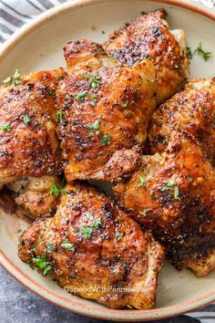 grilled chicken thighs in a bowl with parsley on top