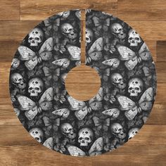 a black and white photo of skulls and butterflies on a circular tablecloth with the letter o