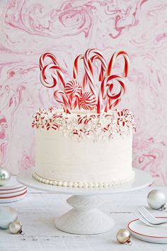 a white cake topped with candy canes on top of a table