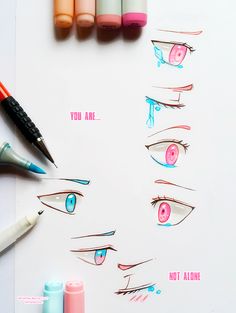 some markers and pens are laying on top of a sheet of paper with different types of eyes