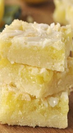 three pieces of cake sitting on top of a wooden cutting board next to lemons