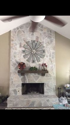 a living room with a stone fireplace and large clock on the wall