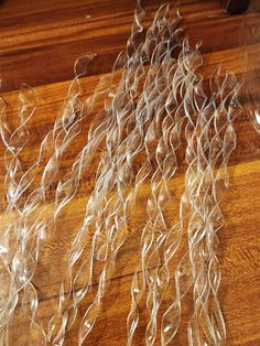 several pieces of clear plastic sitting on top of a wooden table next to a knife