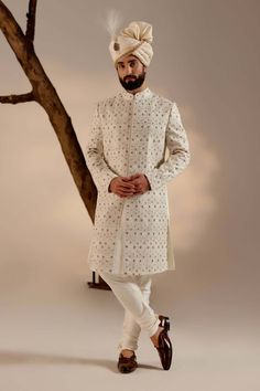 Editor's Note Featuring our infamous kashmiri jamawar embroidered sherwani in dirty ivory color with floral design details. The piece is then highlighted with dabka and zari. Paired with a matching ladakhi pashmina shawl and safa. Fabric: Linen silk Color: White Components: Sherwani, kurta, churidar, pashmina shawl and safa Occasion: Groom Fit: Regular Note: Product colour may slightly vary due to photographic lighting sources Care: Dry clean only About the Designer After establishing himself as Jatin Malik, White Sherwani, Embroidered Sherwani, Blouse Yoke, Turtle Dove, Dhoti Pants, Luxury Footwear, Haldi Ceremony, Indian Man