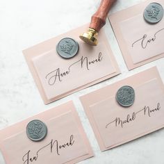 three pink envelopes with waxed seals and some writing on them, next to a rubber stamp