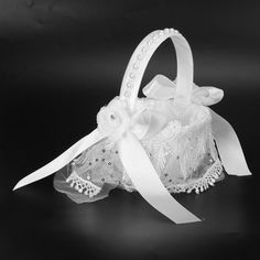 a small white basket with ribbon and lace