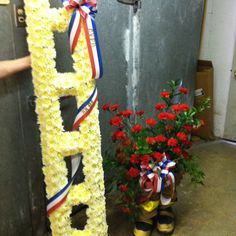 flowers are placed next to a sign with the word dad written on it and someone's feet in yellow rubber boots