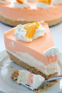 a slice of cake with oranges and whipped cream on top is sitting on a plate