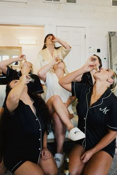 four women sitting on a couch drinking champagne