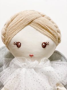 a white doll with brown eyes wearing a dress