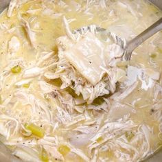 a large pot filled with chicken soup and broth next to a metal ladle