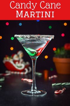 a candy cane martini is garnished with green and red candy canes on the table