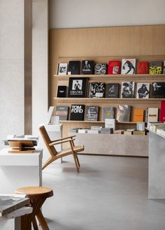 the interior of a book store with books on shelves and wooden chairs in front of them