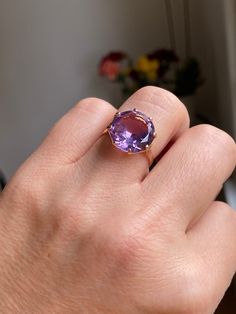 A huge 6 carat amethyst sits in a basket setting of 18k rose gold. This ring is truly a show stopper! The amethyst is synthetic (meaning created in a lab rather than in nature) and sparkles with light purple and blue undertones.  Details: Metal Purity -18k yellow gold (professionally acid tested to confirm) Ring size - 7.5 Weight - 5.3g Amethyst size - 14 mm diameter, 6 carats Ring Rise off of finger - 7.64 mm If this isn't your size, you are welcome to have it sized on your own, OR we can have Elegant Rose Gold Amethyst Ring With Center Stone, Luxury Rose Gold Amethyst Ring, Luxury Rose Gold Amethyst Ring With Center Stone, Elegant Rose Gold Solitaire Amethyst Ring, Formal Rose Gold Amethyst Ring With Center Stone, Classic Rose Gold Amethyst Rings, Luxury Solitaire Amethyst Ring, Classic Rose Gold Amethyst Ring With Prong Setting, Elegant Oval Amethyst Ring In Rose Gold