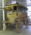 an old fashioned horse drawn carriage in a building