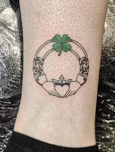 a tattoo on the leg of a woman with a clover in it's center