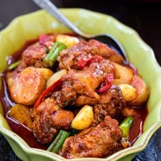 a green bowl filled with meat and vegetables