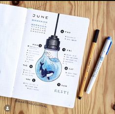 a notebook with an image of a light bulb on it and some pens next to it